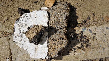 The mortar mixes with the pebbles and black asphalt, when it dry will make an interesting shapes and color, placed on the red ground, when exposed to sunlight causing a beautiful shadow to the ground