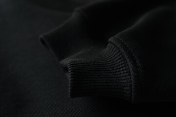 Sleeve of black sweatshirt, close up and space for tet
