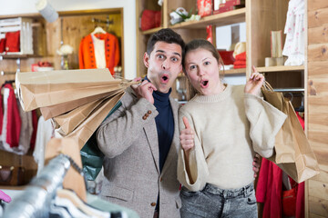 Couple is satisfied shopping in the clothes store.