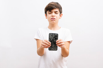 Dark haired boy holding a broken smartphone with a crying expression