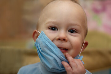 toddler does not want to put on and pulls down the medical mask