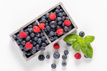 blueberries and raspberries in wooden crates.