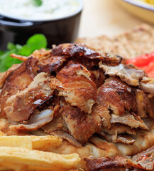 Gyros grilled meat slices on a pita bread, closeup view