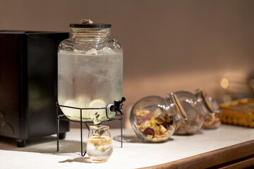 Closeup shot of a container of water with ice and lemon on the refreshments table