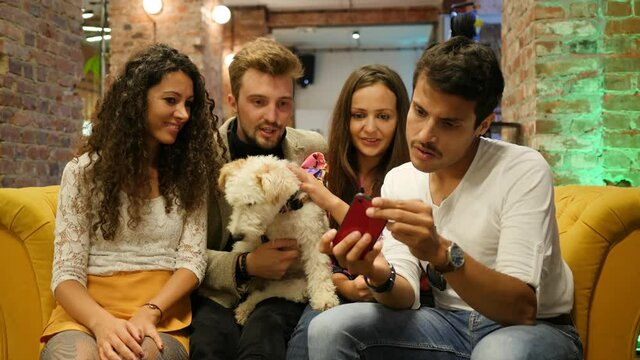 Friends with pet dog in bar take smartphone selfie picture hangout together having fun