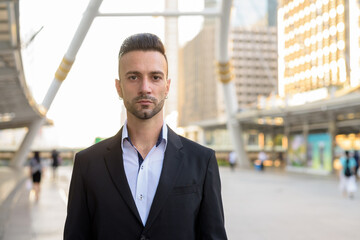 Portrait of handsome young businessman outdoors in city