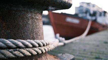  boat is attached to a steel bollard in the harbour with a large rope