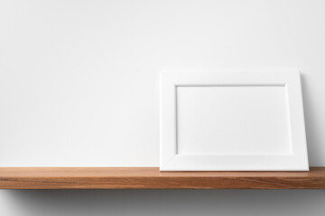 horizontal white wood photo on bookshelf and wall