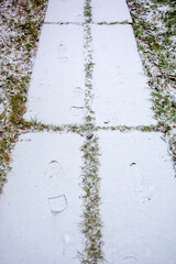 Fresh bootprints in the snow. The first snow on the path. Beginning of winter.