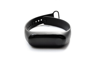 Black smart fitness bracelet, activity tracker on a white background. Sports electronic watch with LCD display and rubber flexible wrist.