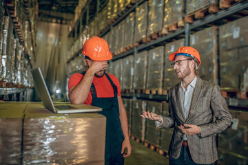 Manager talking to the warehouse worker and critisizing his work