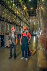 Manager talking to the worker while inspecting the warehouse