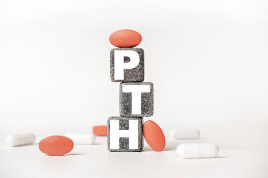 a group of white and red pills and cubes with the word PTH Parathyroid hormoneX on them, white background. Concept carehealth, treatment, therapy.