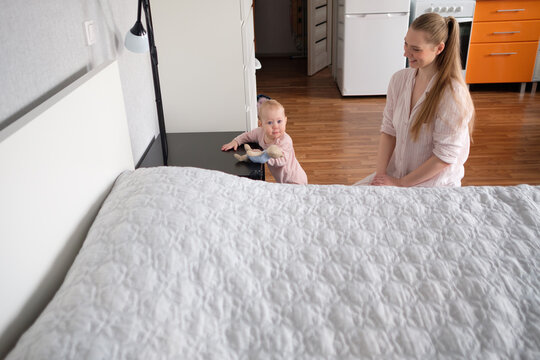 Beautiful Young Woman And Her Charming Little Daughter Playing At Home