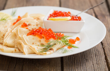 red caviar with pancakes on wooden table