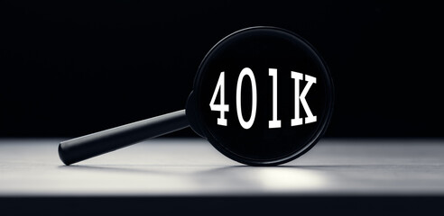 Magnifying glass with the word 401K on table. Search idea