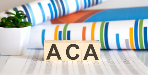 ACA written on a wooden cube on chart background