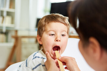 Pediatrician examines child with tonsillitis