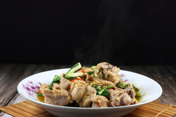 Fried and stirred spicy chicken meat with spring onion, chilly and seasoning with soy sauce and pepper on the plate. Famous traditional appetizer menu in Asia restaurant. 