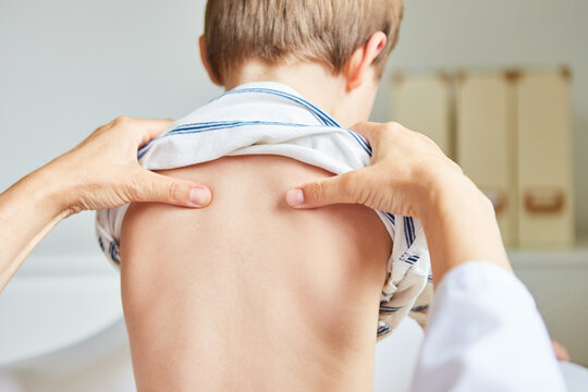 Osteopath makes acupressure on child's back