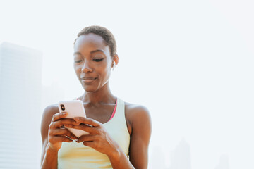 Sport woman using moblie phone and bluetooth earphones