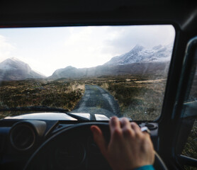 Man driving a car in the Highlands, Scotland