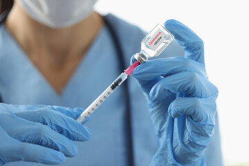Doctor drawing medicine into syringe from vial in laboratory of clinic closeup. Vaccine prophylaxis covid 19 concept