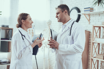 Male doctor looking at young female doctor. 