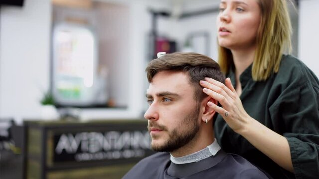 Stylish man sitting barber shop Hairstylist Hairdresser Woman cutting his hair 