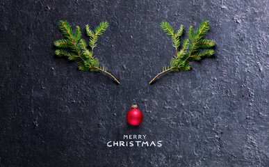 Christmas Concept - Reindeer Made With Fir Branches And Red Bauble On Black Stone