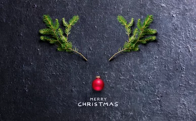 Gordijnen Christmas Concept - Reindeer Made With Fir Branches And Red Bauble On Black Stone © Romolo Tavani