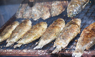 Roast anabas is on the stove, using charcoal to cook.