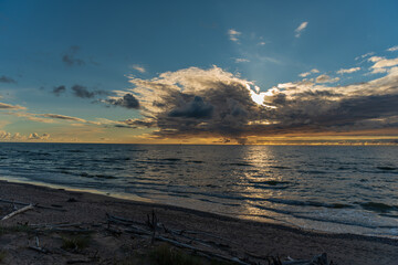Obraz premium sunset behind the clouds close to the water horizon