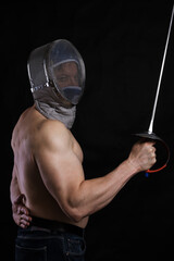Matured man with naked muscular torso in fencing helmet and epee