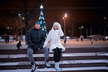 Obraz premium couple on ice rink evening, lovers christmas sport winter holidays