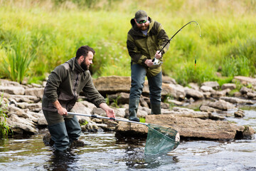 Naklejka premium two men are fishing on the river
