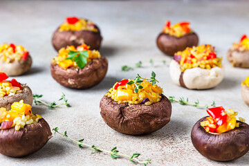 Stuffed portobello mushrooms with bulgur, vegetables and aromatic herbs on concrete background. Vegetarian food.