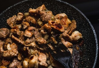 meat and vegetables cooking on a pan