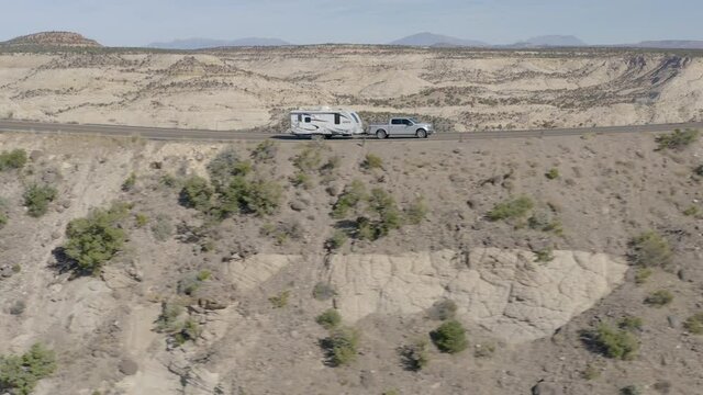 Pickup Truck Tows Camper Trailer Along Narrow Hogback located on Utah Scenic Byway 12 in the Mountain West during Domestic Tourism High Season