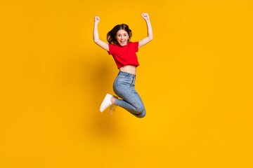 Fototapeta na wymiar Full length photo of ecstatic girl jump win raise fists scream isolated over bright shine color background