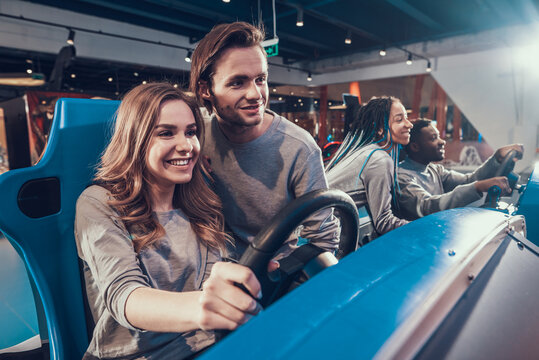 Blonde girl with a guy ride a toy car. 
