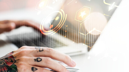 Fototapeta premium Tattooed hand using a laptop