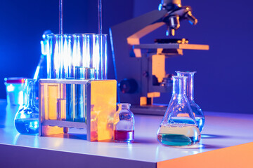 Laboratory glassware close-up. Laboratory glassware on table next to microscope. Test tubes of different shapes in laboratory. Concept - sale of test tubes for lab. Glassware for scientific research.