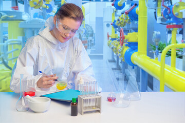 Laboratory assistant at a chemical factory. Girl works in laboratory. Woman chemist near pipes....