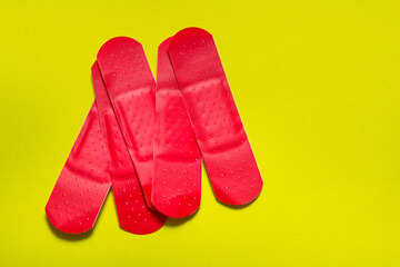 Set of colored first aid plasters on green background