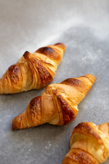 Freshly baked croissants on beautiful textured concrete background