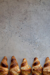 Freshly baked croissants on beautiful textured concrete background