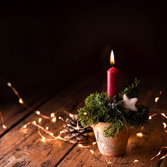 Christmas candle on rustic wood background in old clay pot, Advent decoration with magic lights and...