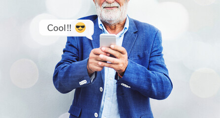 Stylish elderly man texting on his smartphone