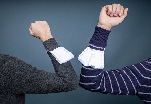 two people greeting each other with elbows